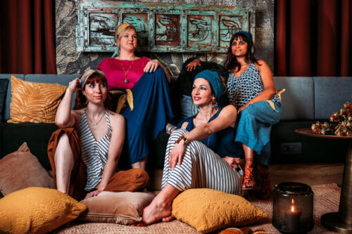 4 femmes assises dans un fauteuil au style oriental portant les vêtements Sosol and Sea