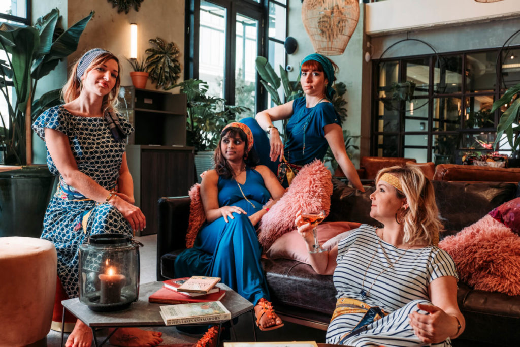 4 dames au look bohème chic assises dans un salon