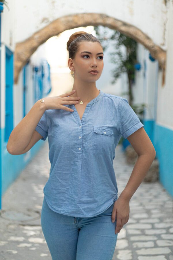 Mannequin féminin dans une ruelle portant le bracelet, le collier et les boucles d'oreilles en forme de coquillage de Sosol and Sea