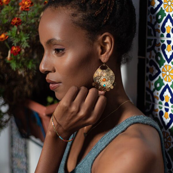 Mannequin portant des boucles d'oreilles en or martelé arrondies avec trois pierres semi-précieuses