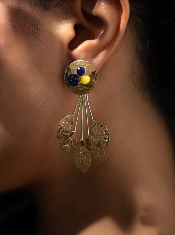 Mannequin portant des boucles d'oreilles pendantes en or martelé rondes et un design de feuille