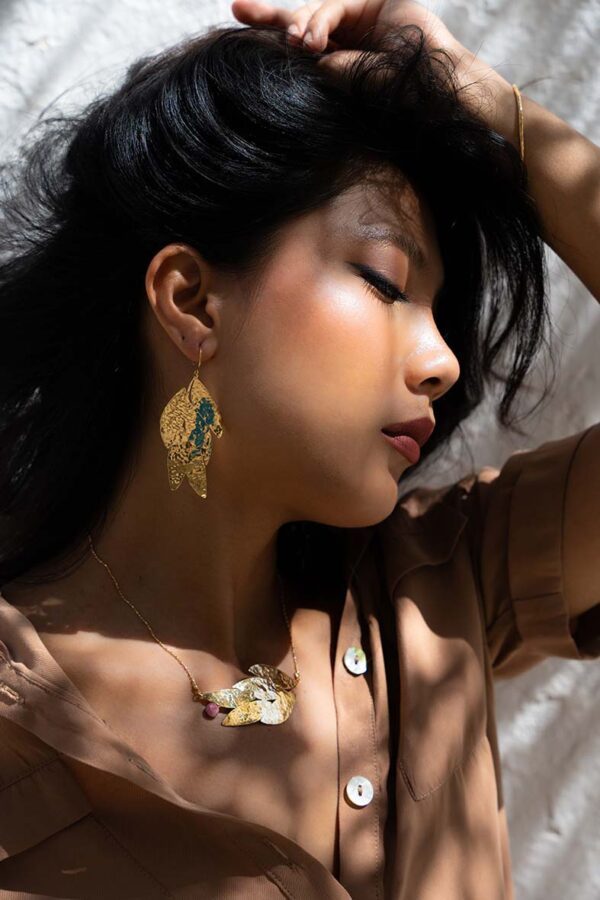 Femme portant des boucles d'oreilles et un collier en or martelé Sosol and Sea